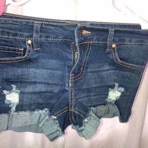 Dark blue ripped shorts with brown stitching